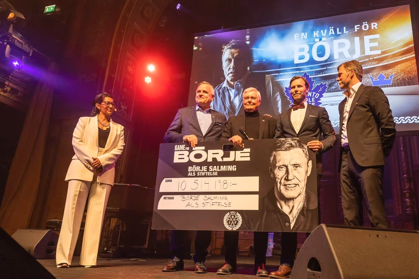 Fyra män och en kvinna på scen håller en stor check från Börje Salming-stiftelsen med summa tio miljoner kronor, under evenemanget En kväll för Börje.