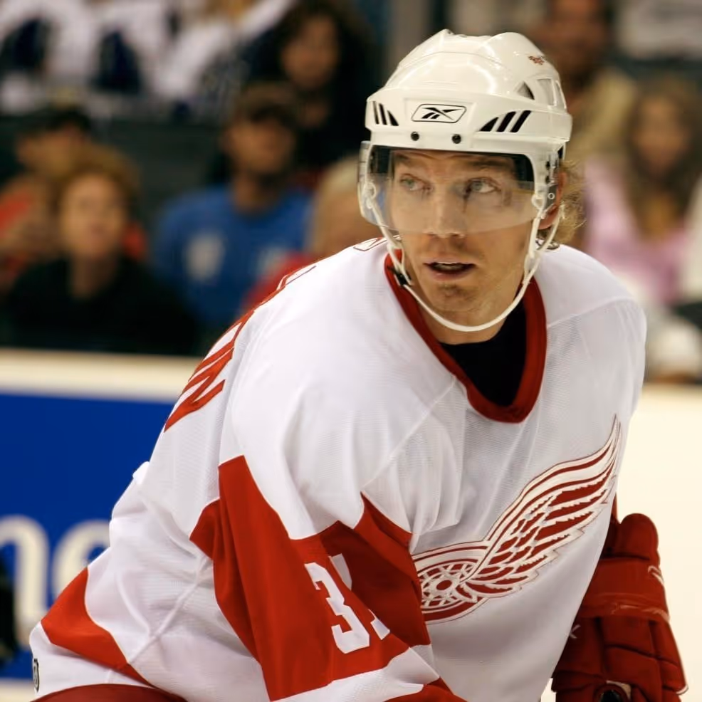 Ishockeyspelare i vit och röd Detroit Red Wings-tröja med nummer 31 och hjälm som ser åt sidan under en match.