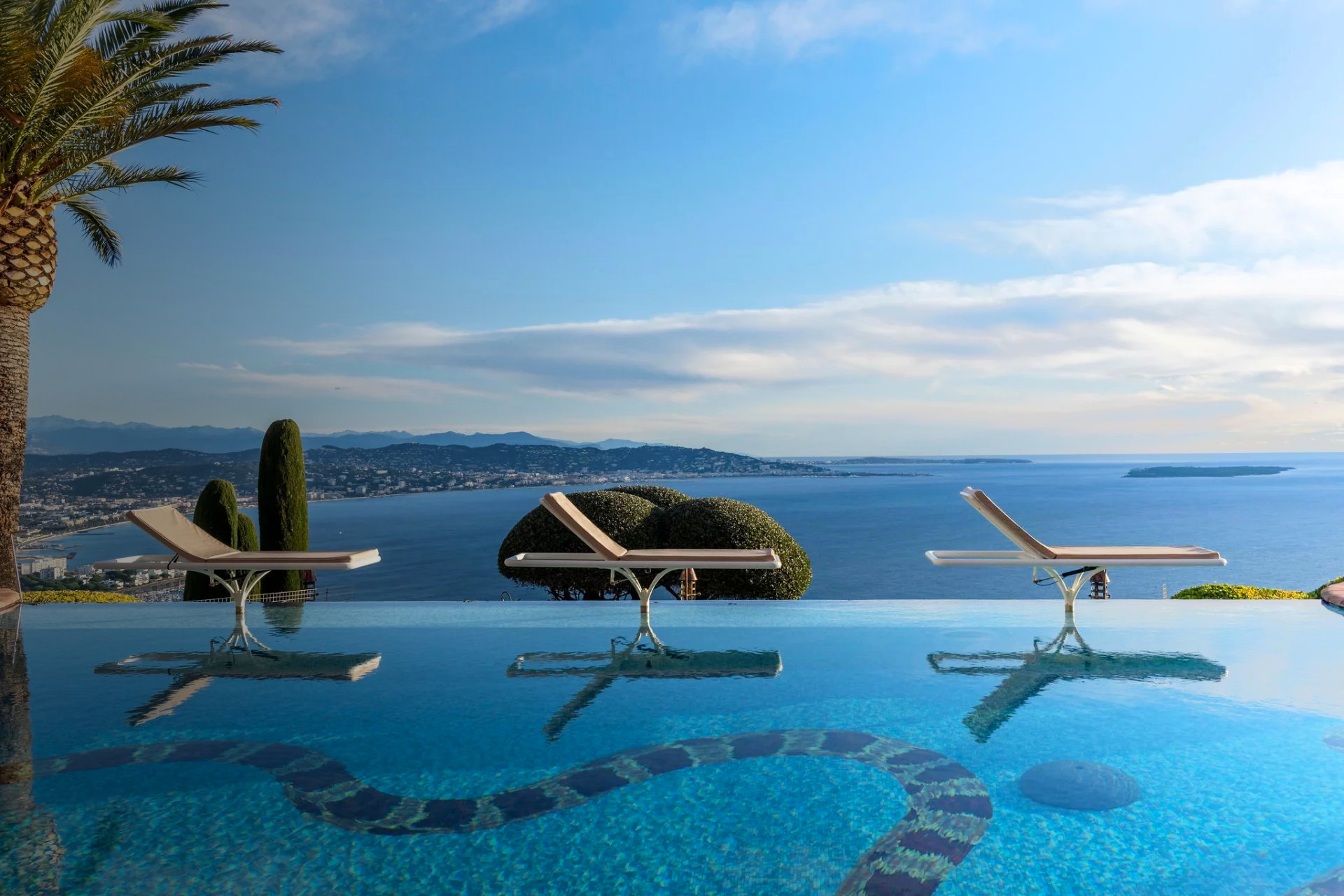 Infinity pool and sun loungers overlooking the French Riviera