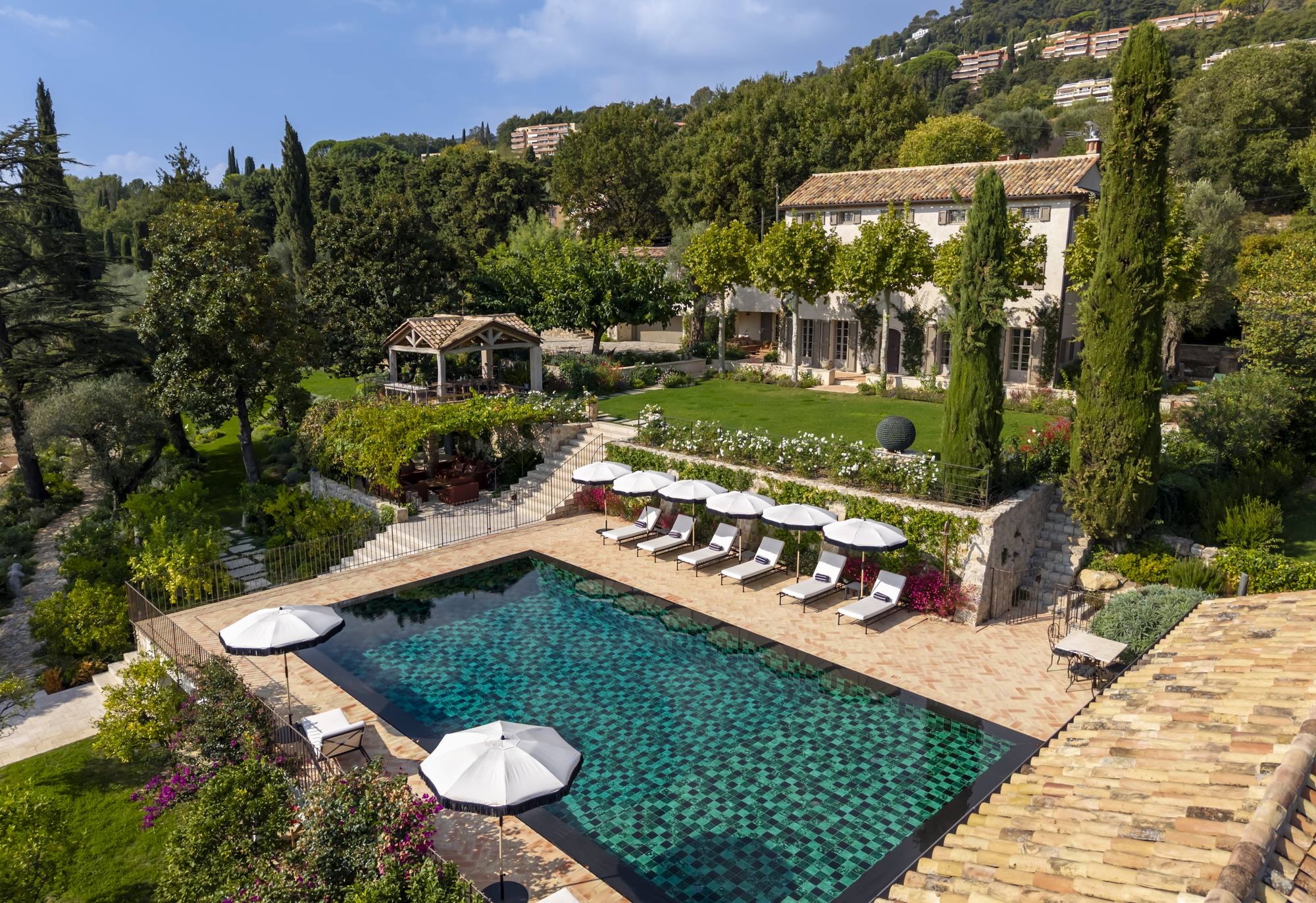 Aerial view of a Back Country estate, pool and gardens against the hillside