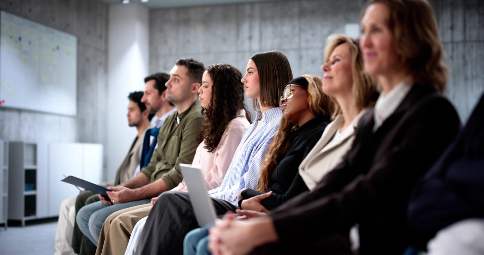 Employees waiting for job interviews in diverse office setting
