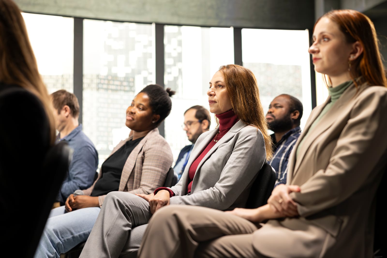 seated female entrepreneur in attendance paying attention to pitch-presentation