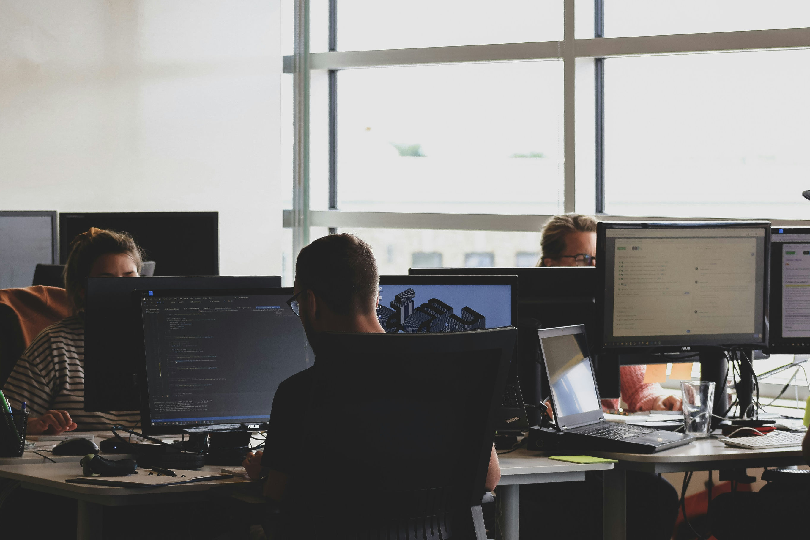 IT professionals working at a busy office setup, representing a Managed Service Provider (MSP) team managing and monitoring business IT solutions.