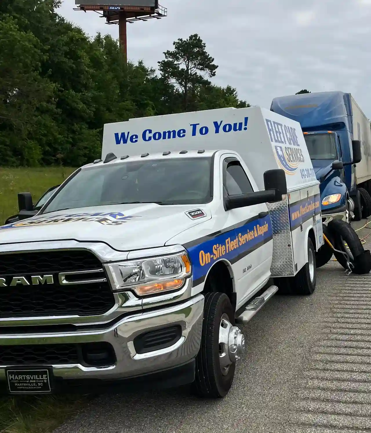 Roadside service truck assisting a disabled semi-truck on the highway. Visible text: "We Come To You!" and "Fleet Care Services."