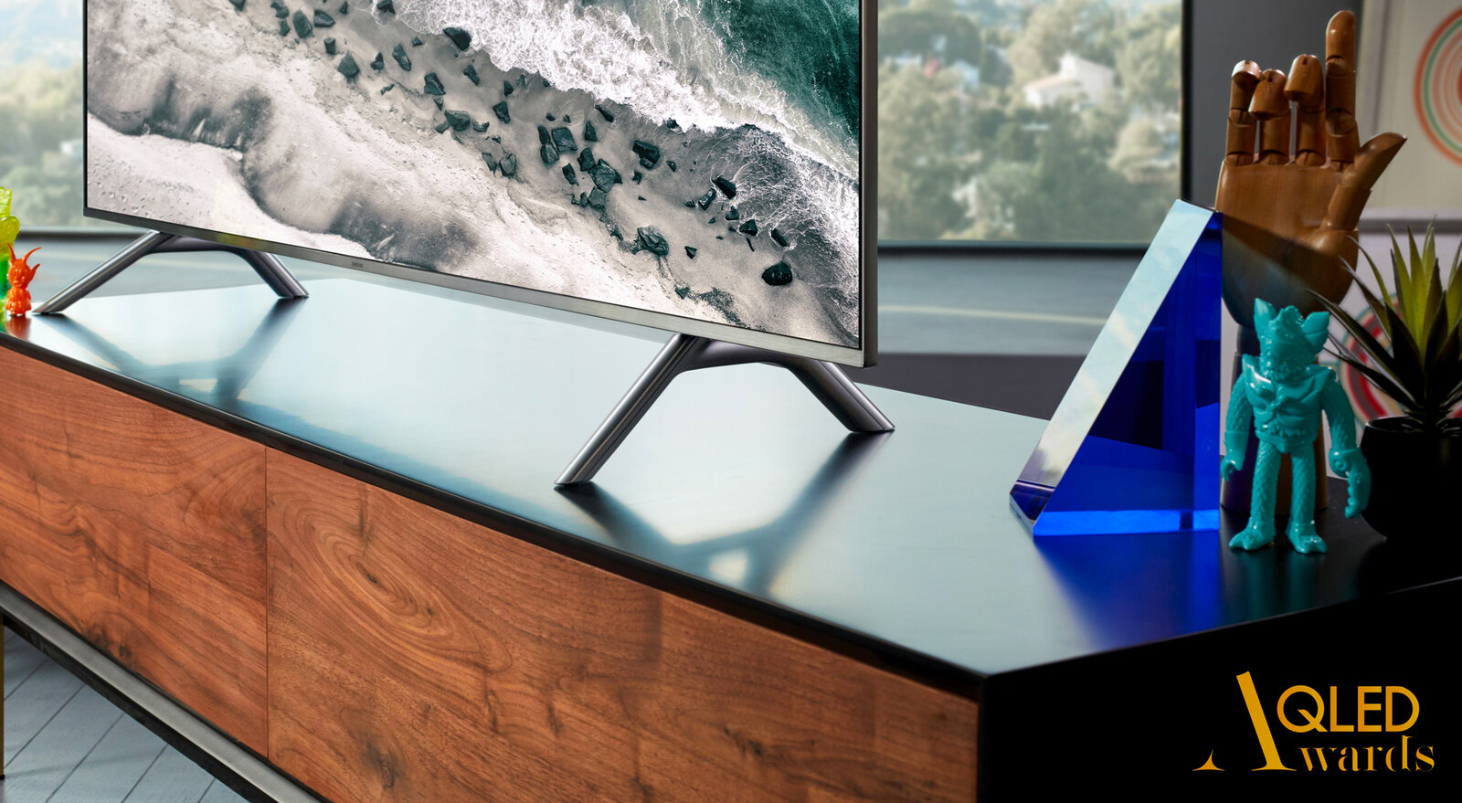 Samsung QLED Awards : un téléviseur QLED sur un meuble en bois, le logo QLED Awards en bas à droite