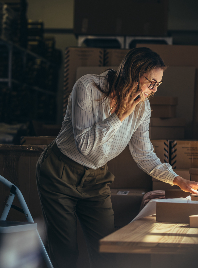 Woman on phone shipping packages