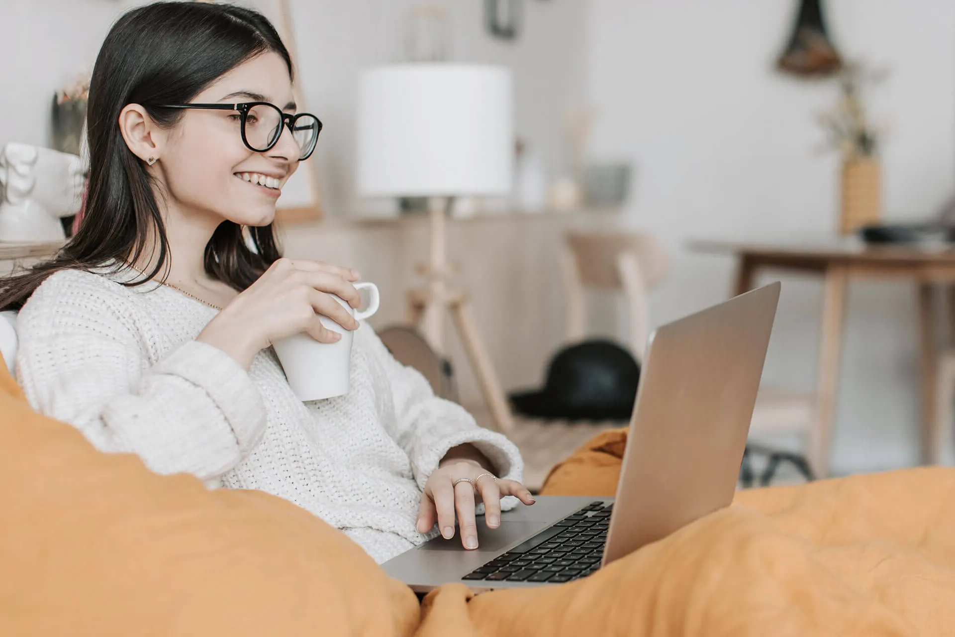 a woman sitting on a bed with a laptop