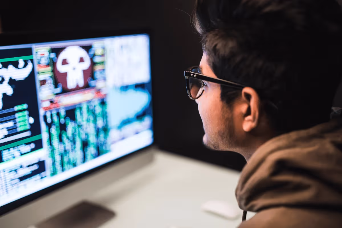 A person focused on a monitor displaying complex data and graphics, highlighting coding or cybersecurity information.