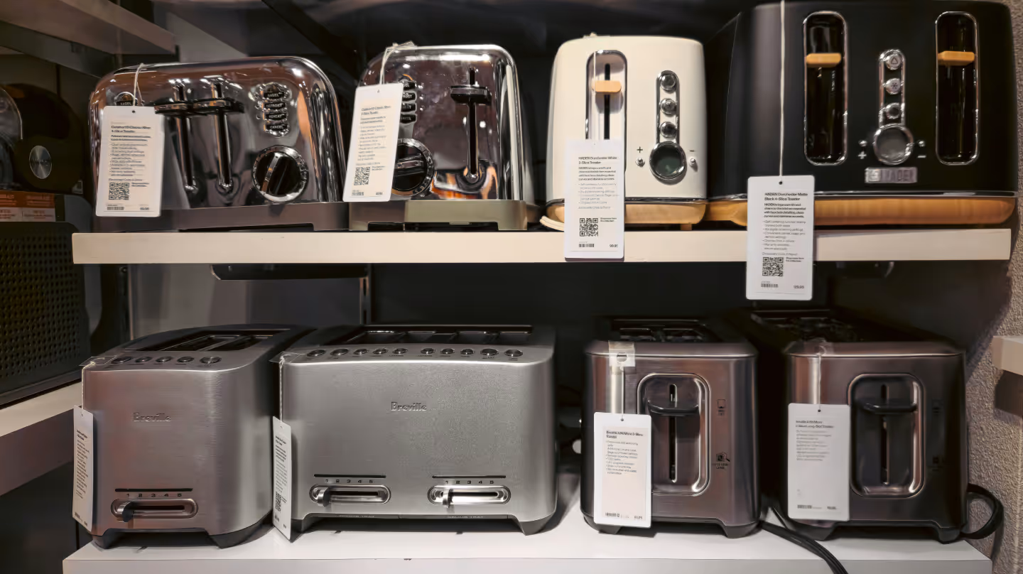 Toasters of different brands with QR code labels on store shelves – symbolizing how digital product passports bring transparency on repair and sustainability to small appliances like toasters.