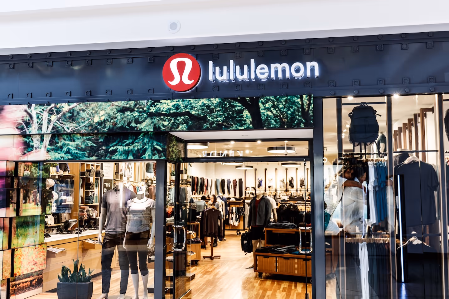 Lululemon storefront in shopping mall with mannequins and athletic wear displayed inside