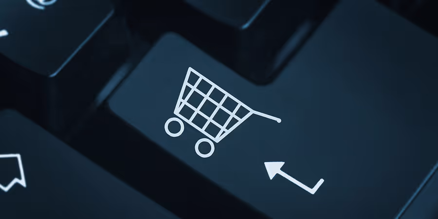 A computer keyboard featuring a shopping cart symbol.