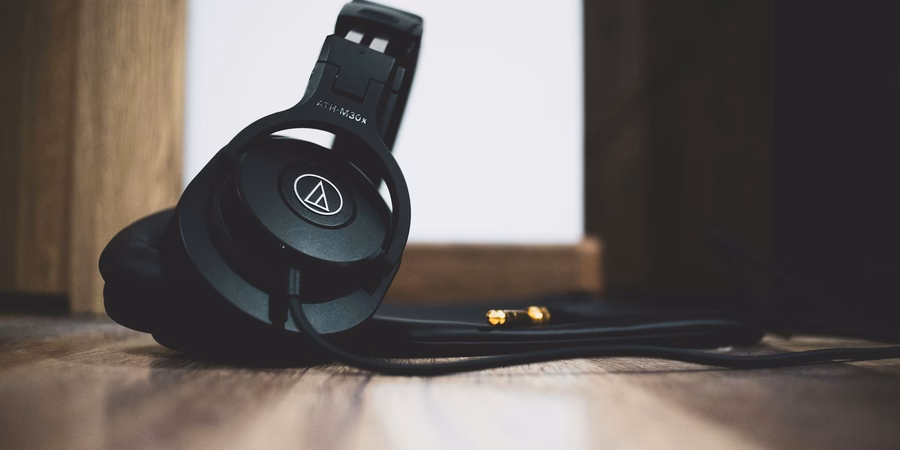 Refurbished over-ear headphones on a wooden floor, symbol of audio resale value
