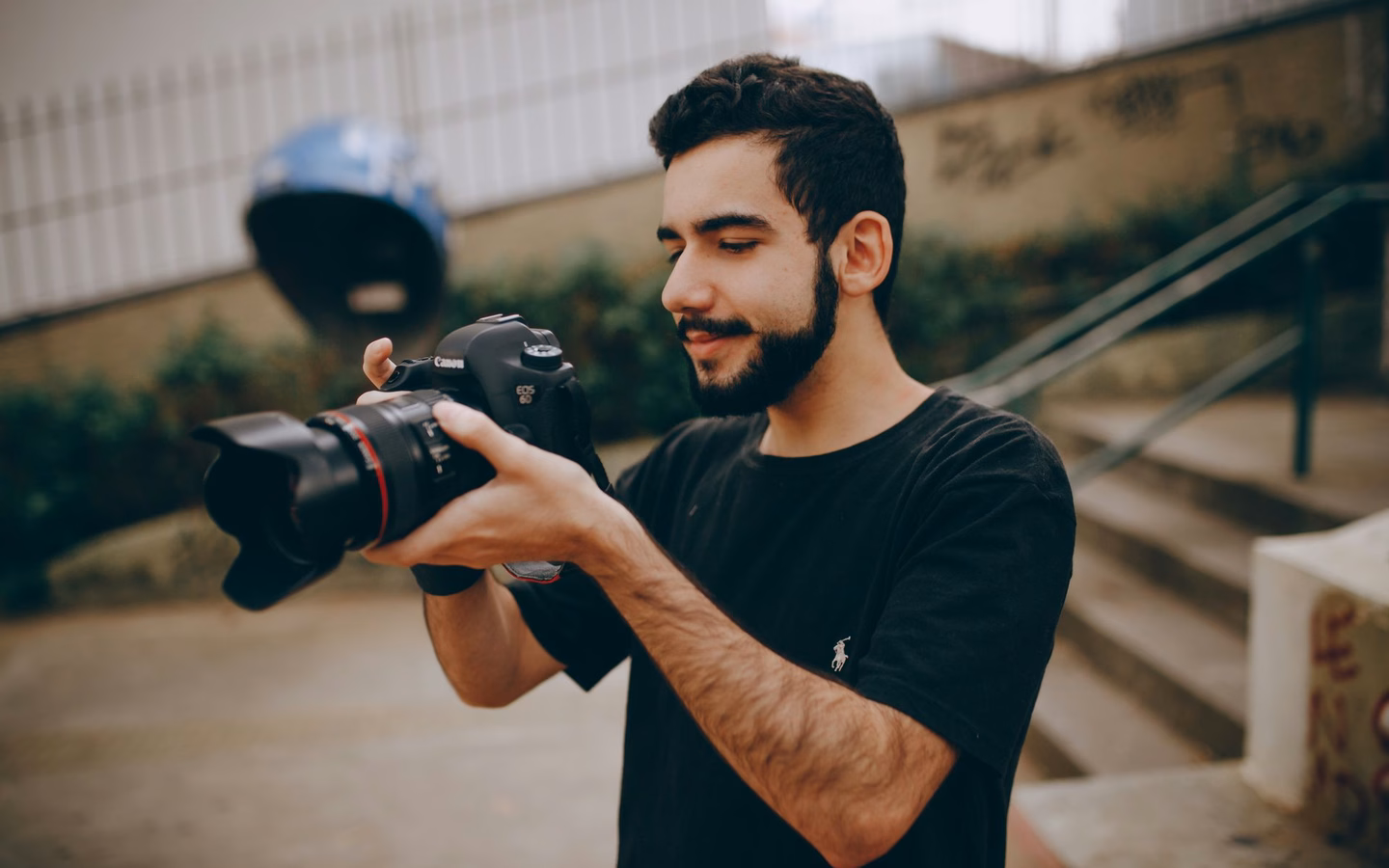 Fotograf:in begutachtet eine gebrauchte spiegellose Kamera