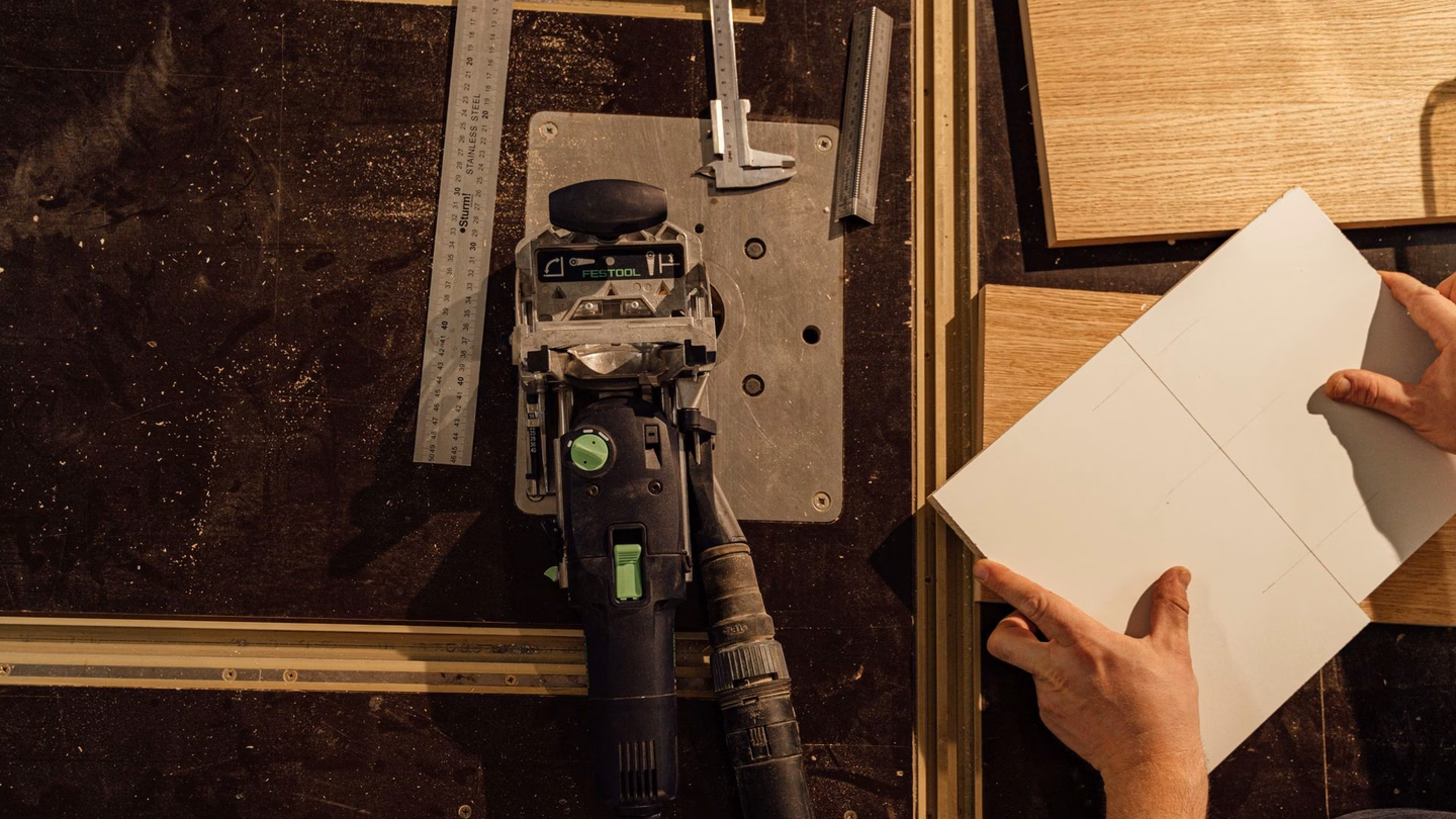 Used Festool plunge saw on a workshop bench with measuring tools and oak panels