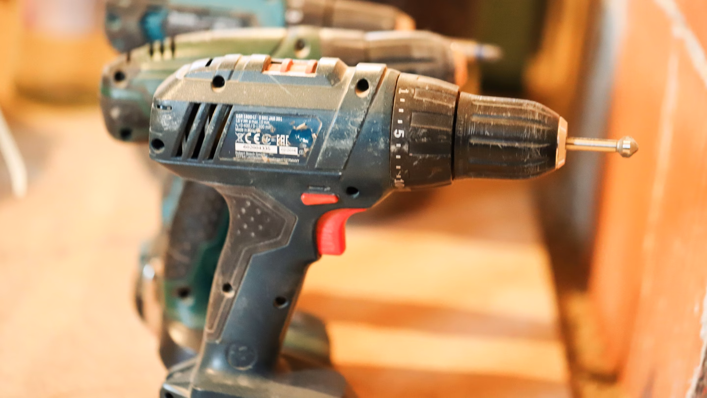 Row of used Bosch professional cordless drills showing wear, still functional