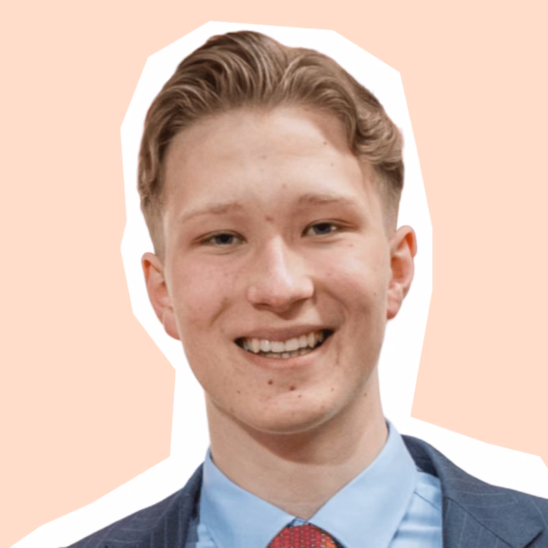 Linus Pastor lächelt im blauen Nadelstreifenanzug mit roter Krawatte, Porträt aus dem koorvi-Team