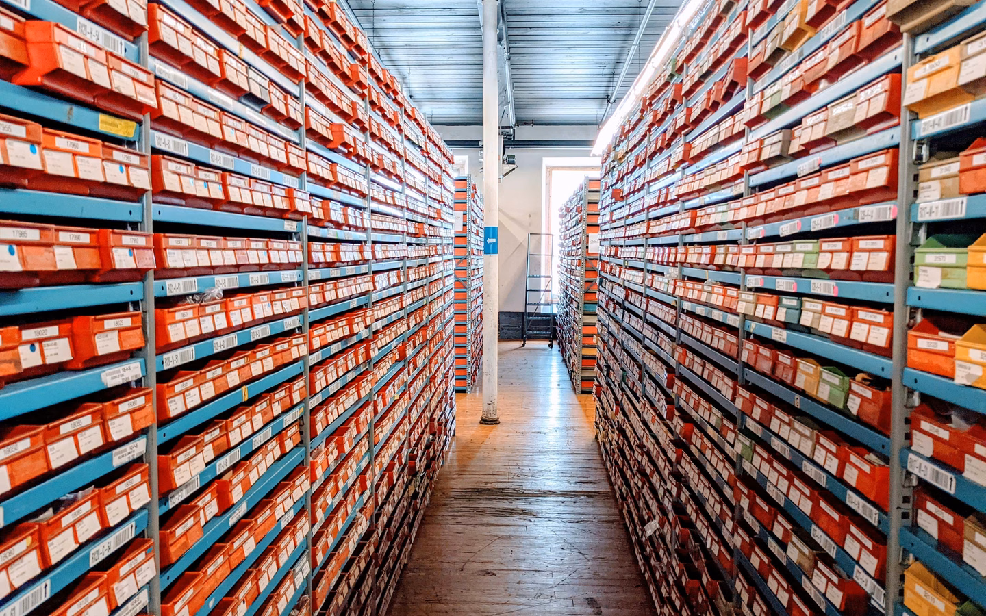 Gang in einem Ersatzteillager mit tausenden beschrifteten Kleinteilekästen in Regalen
