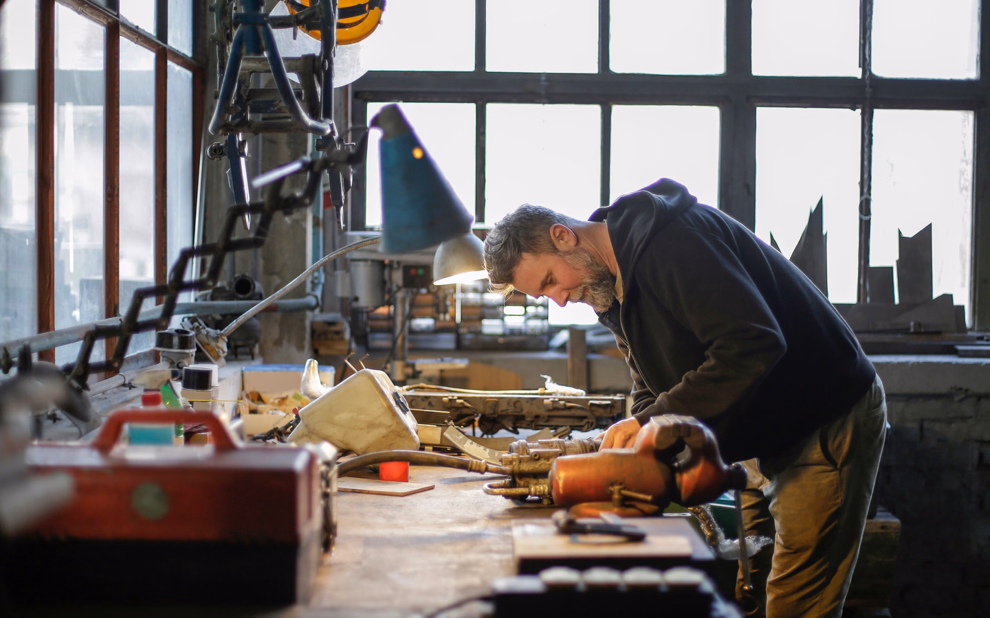 Technician inspecting a used product at a workbench in a repair workshop.