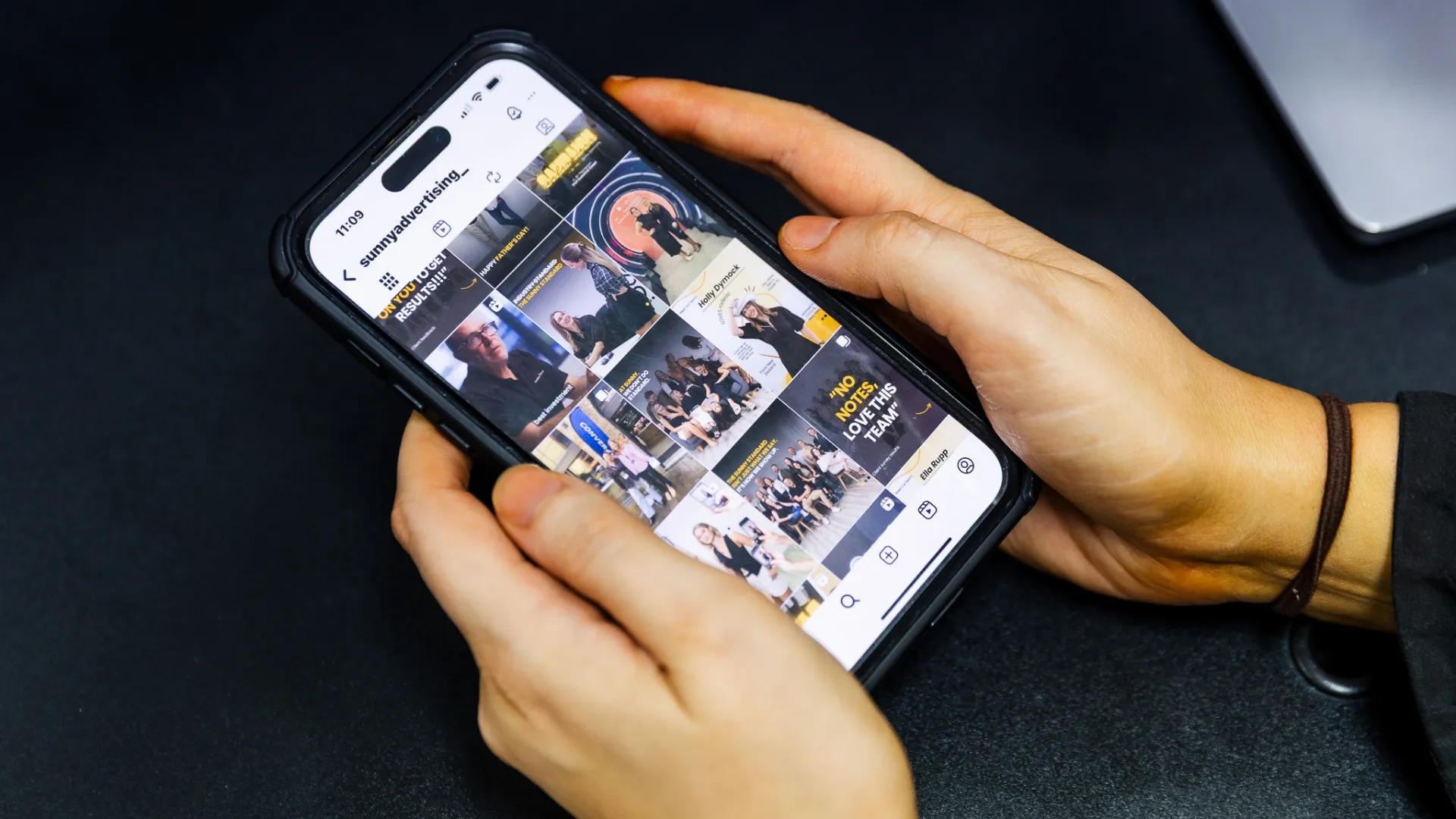 Person holding phone looking at Sunny Advertising Instagram