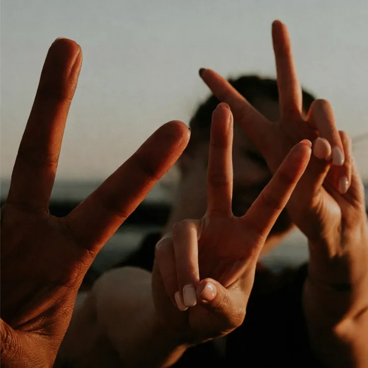 Tre personer gör victory signs