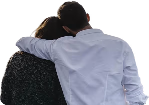 Couple with man in white shirt hugging woman from behind, heads leaning close together.