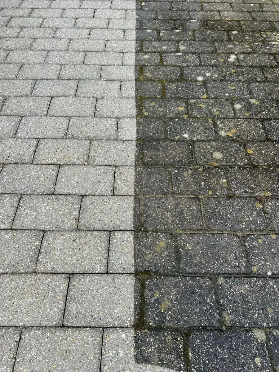 Side-by-side comparison of a cleaned grey stone pavement on the left and a dirty, mossy grey stone pavement on the right.