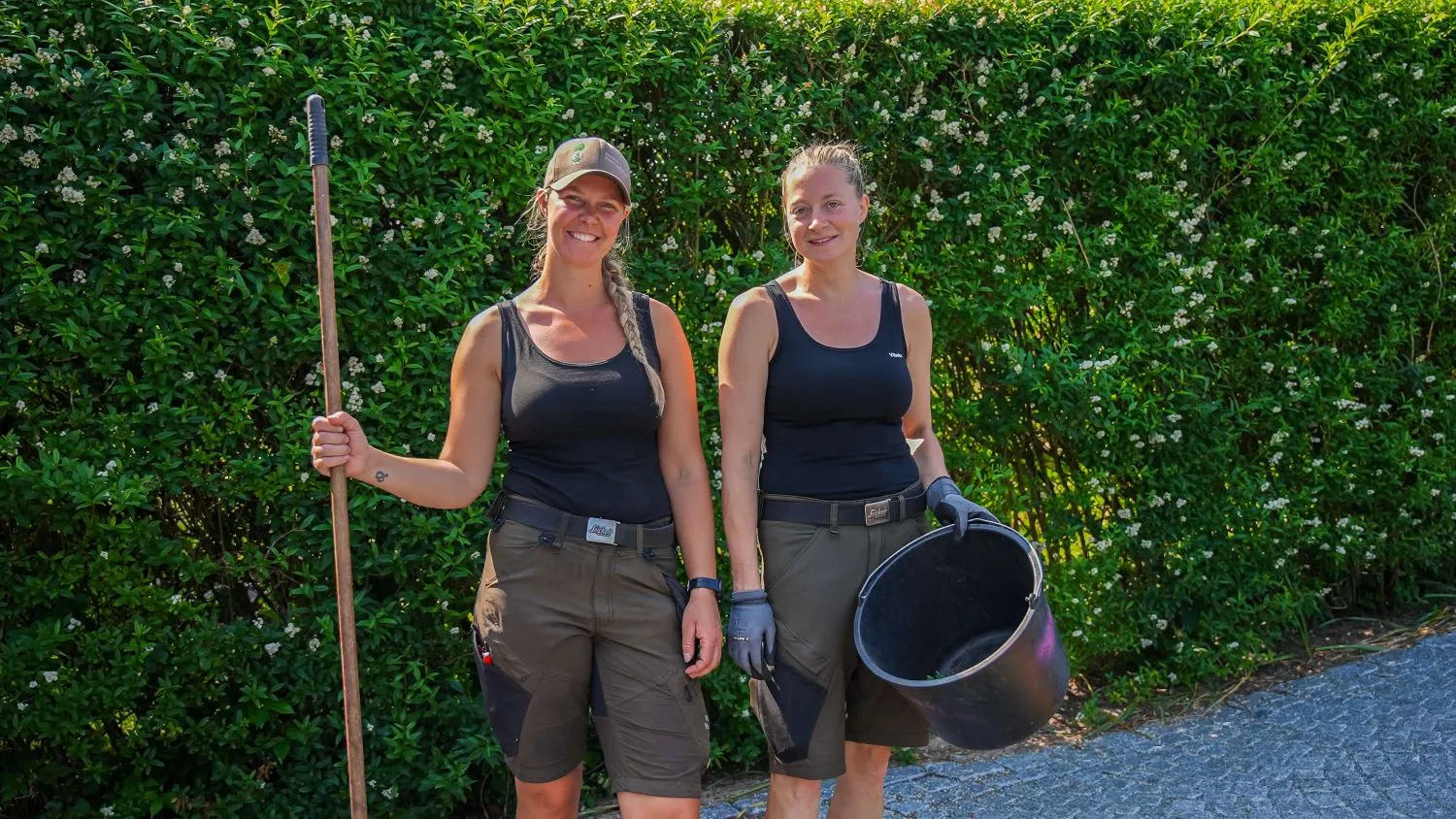To kvinder står ved siden af hinanden i en indkørsel
