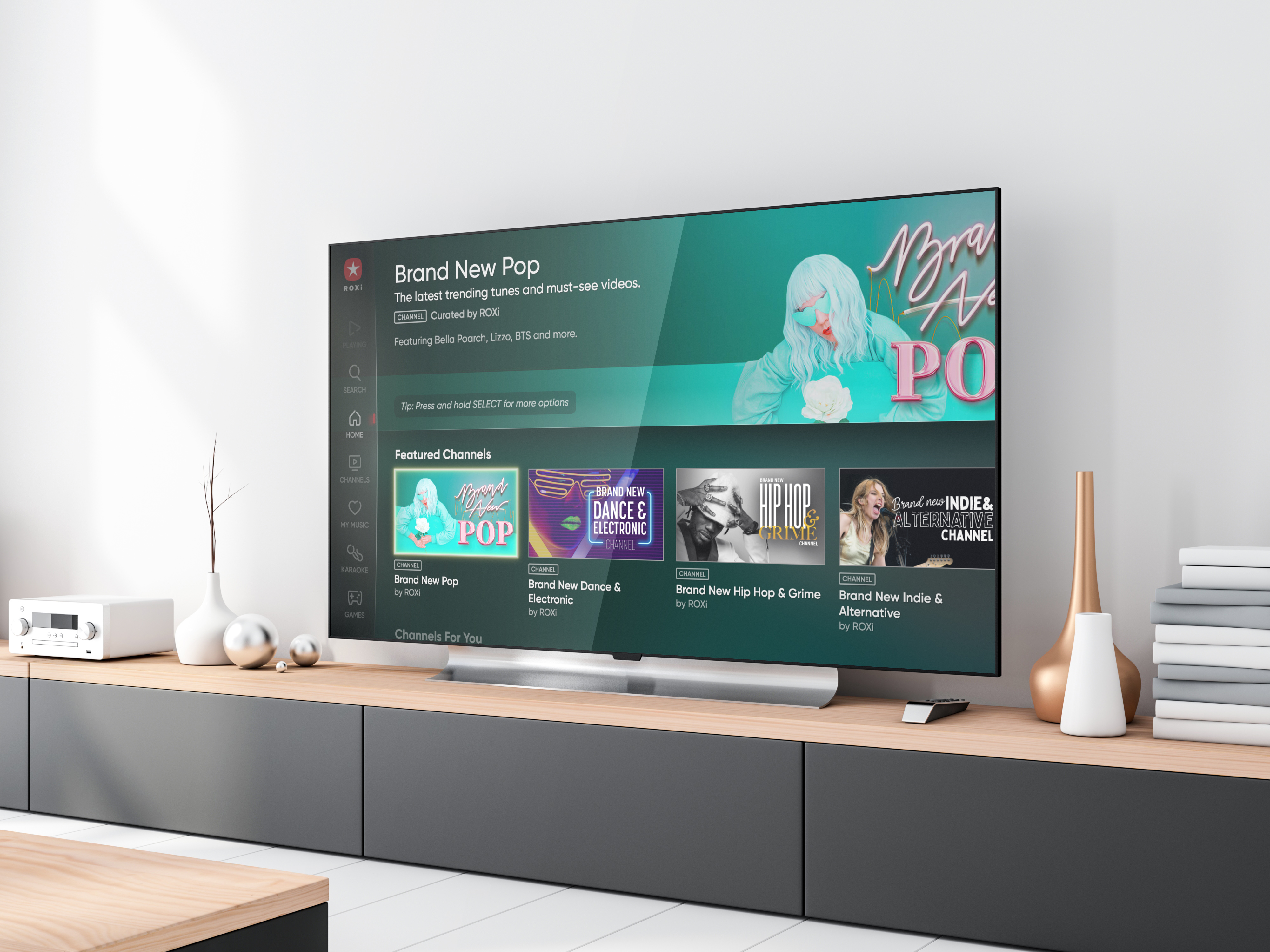 A large TV in a minimalist room showing the Roxi platform 