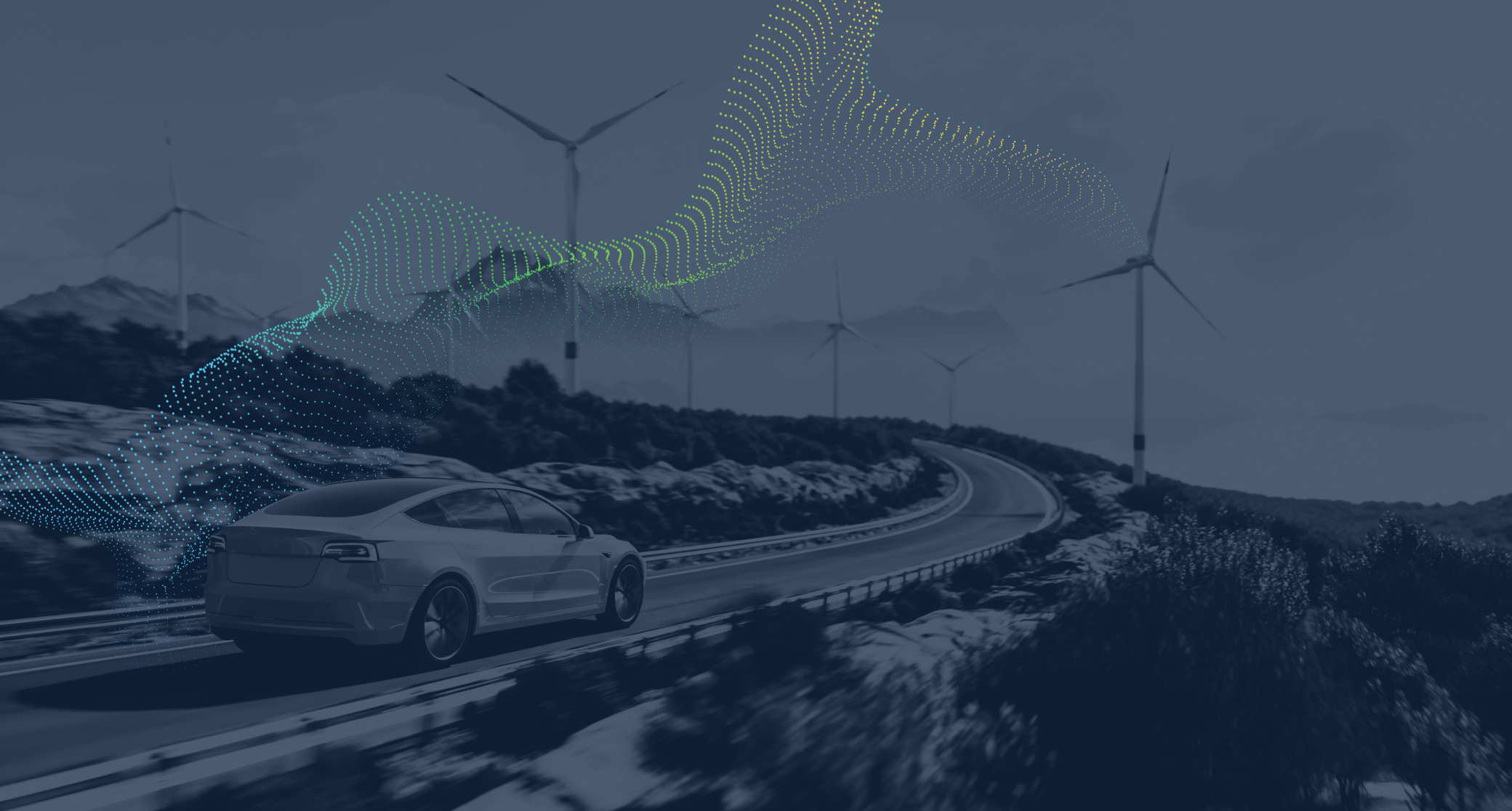 car on a sweeping road with wind turbines on the hill