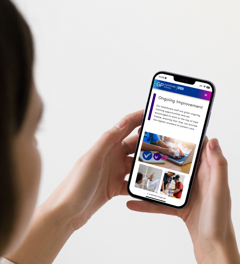 over the shoulder view of a woman holding a phone showing the GP Pathfinder Clinics website