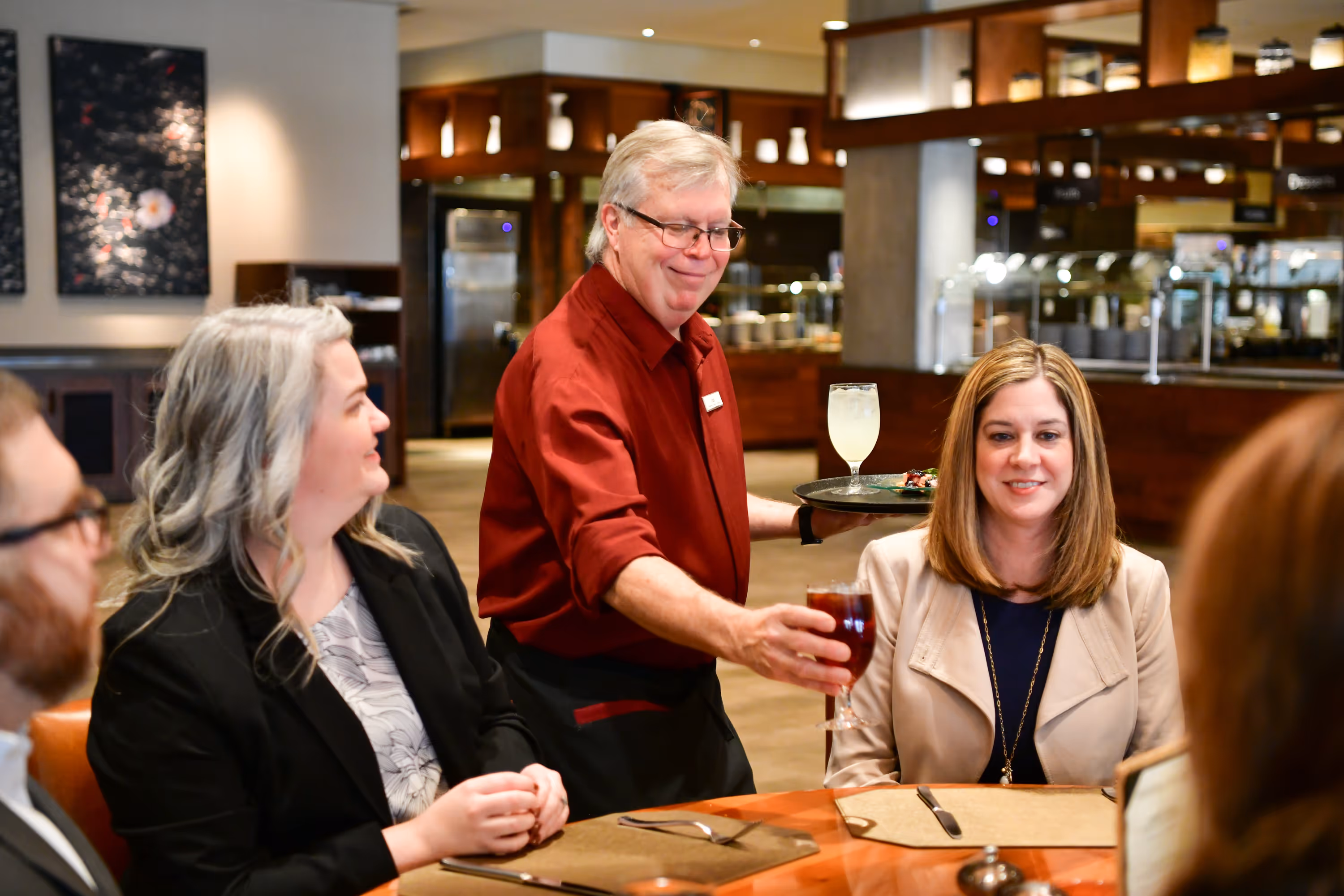 Server serving a drink to customers