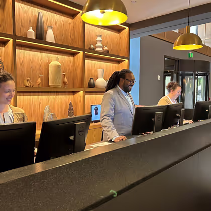 Front desk agent smiling and looking at computer screen. 