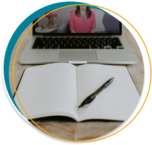 A laptop and notebook open with a pen on a desk. On the laptop is one of Fab Fempreneurs' course videos.