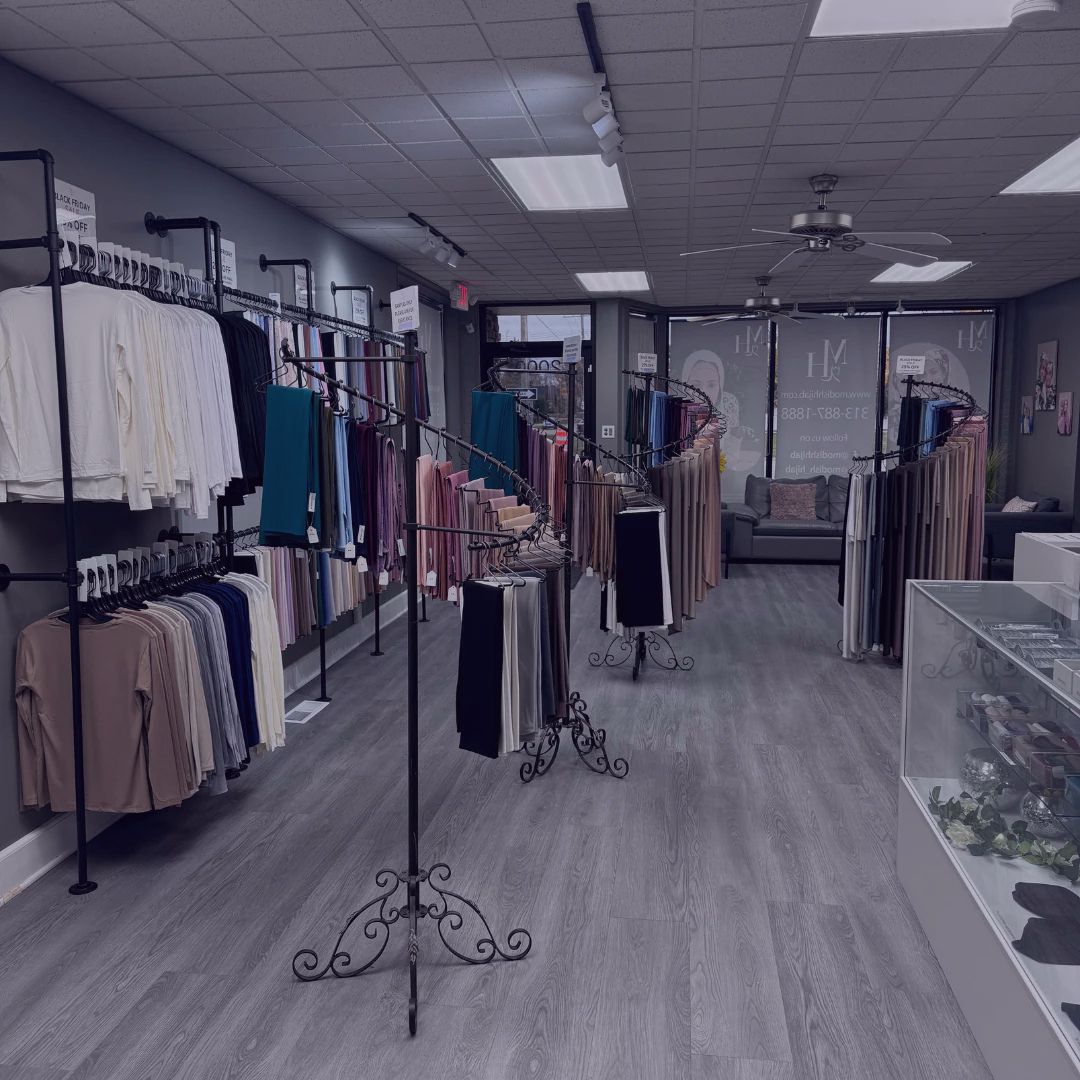 Retail display of modest fashion items arranged by color in a boutique setting.