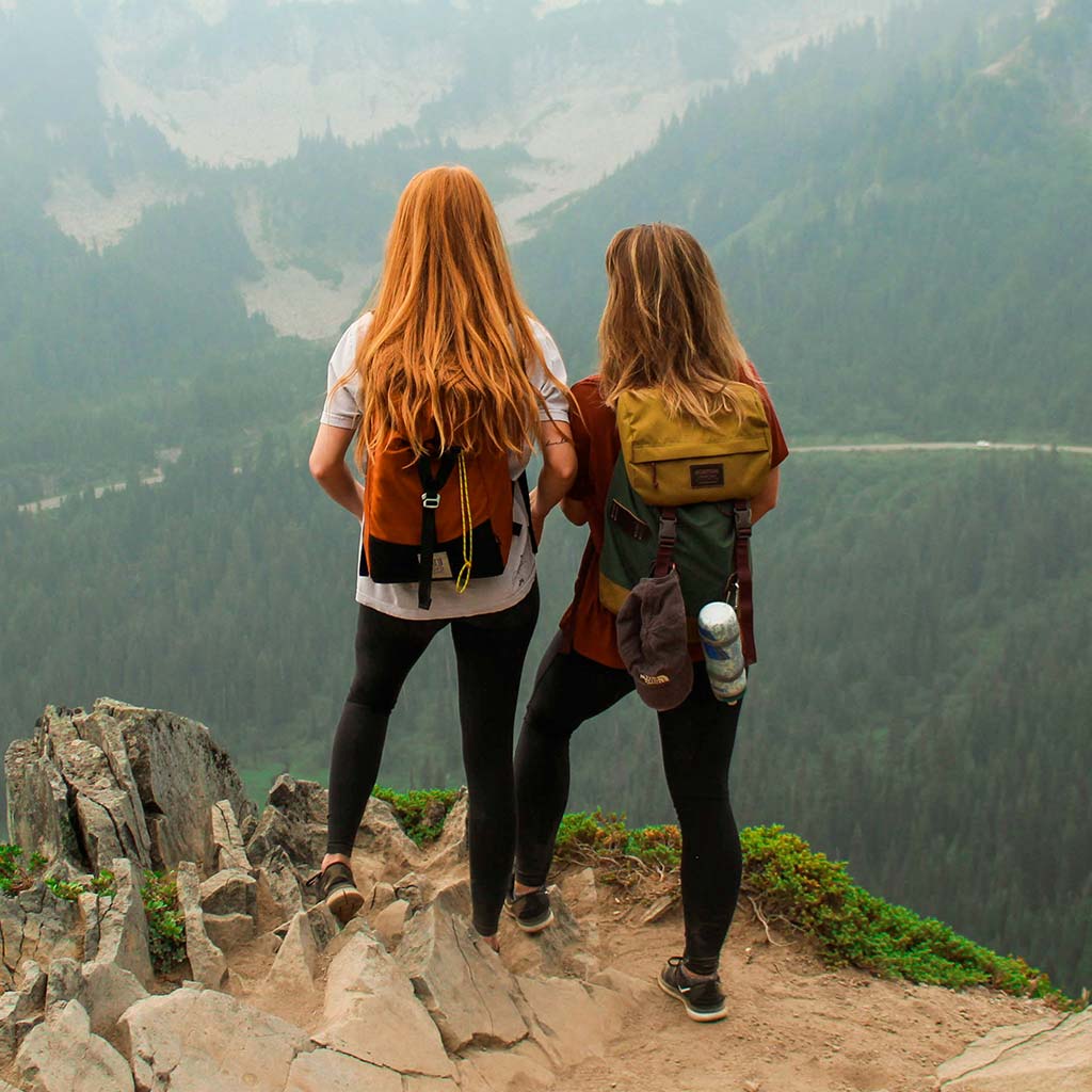 Zwei Wanderer schauen von Gipfel in die Berge