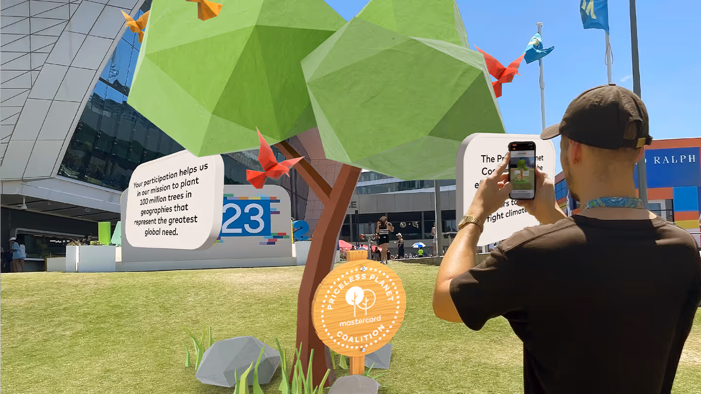 A person holding their phone, interacting with an AR tree.
