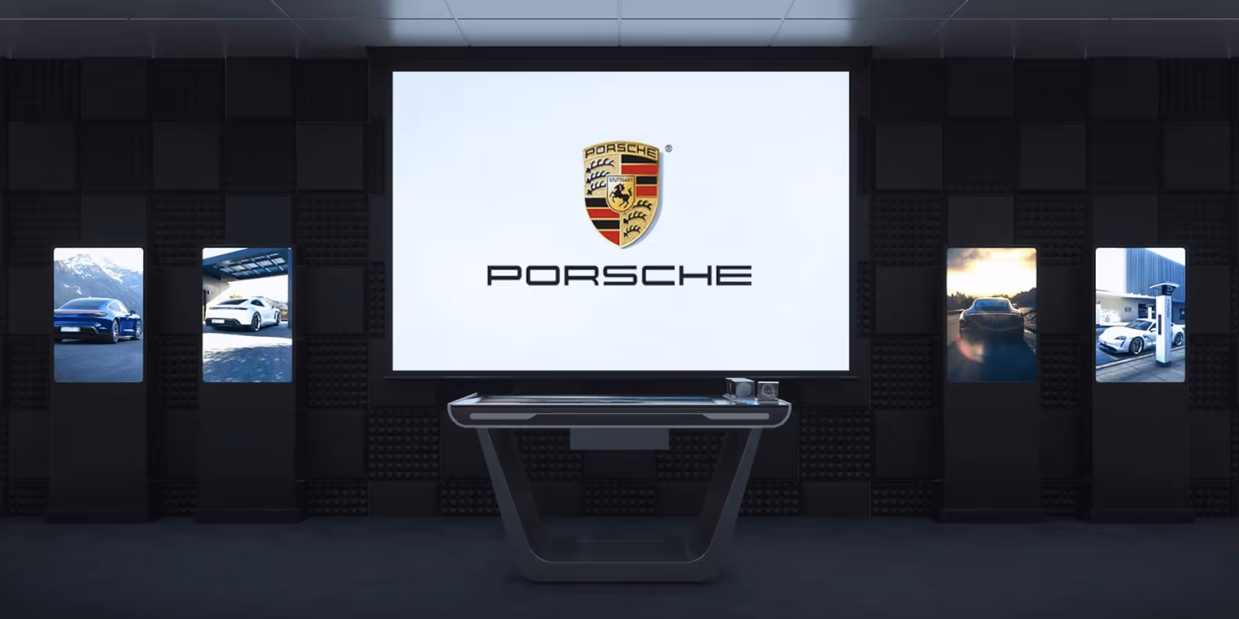 A room with a glass table and Porsche logo on the wall.