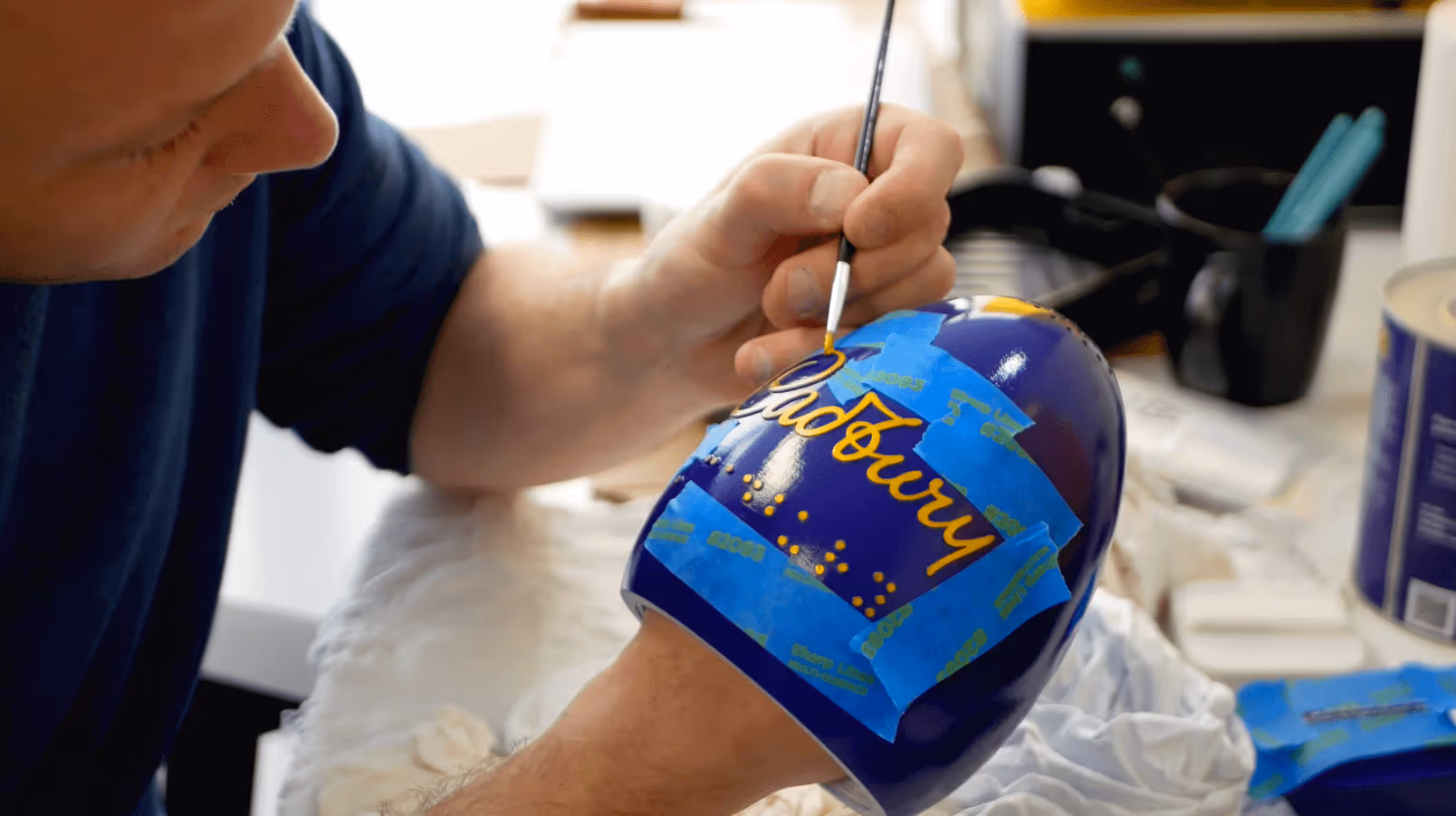 A person painting a Cadbury egg.