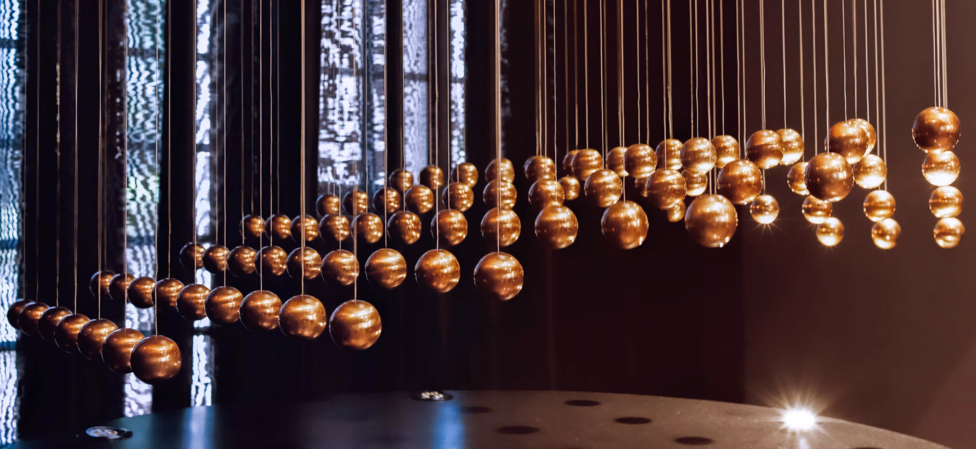 A number of metallic orbs hanging in a room.