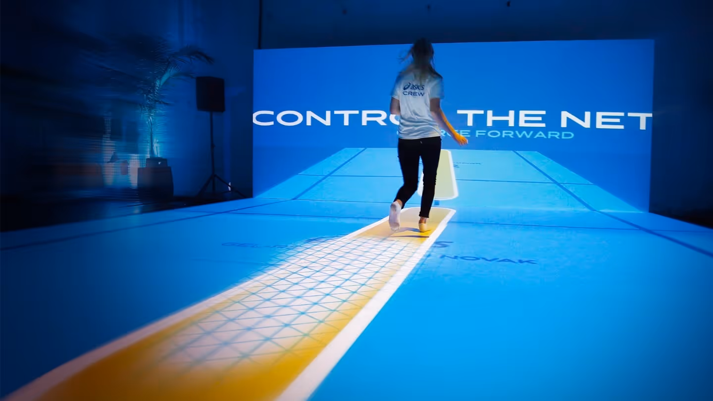A person moving on an interactive tennis court.