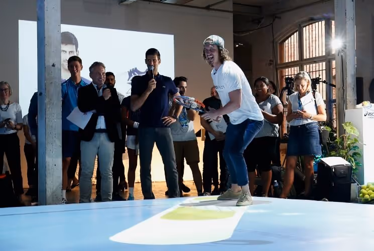 A person standing on an interactive tennis court.