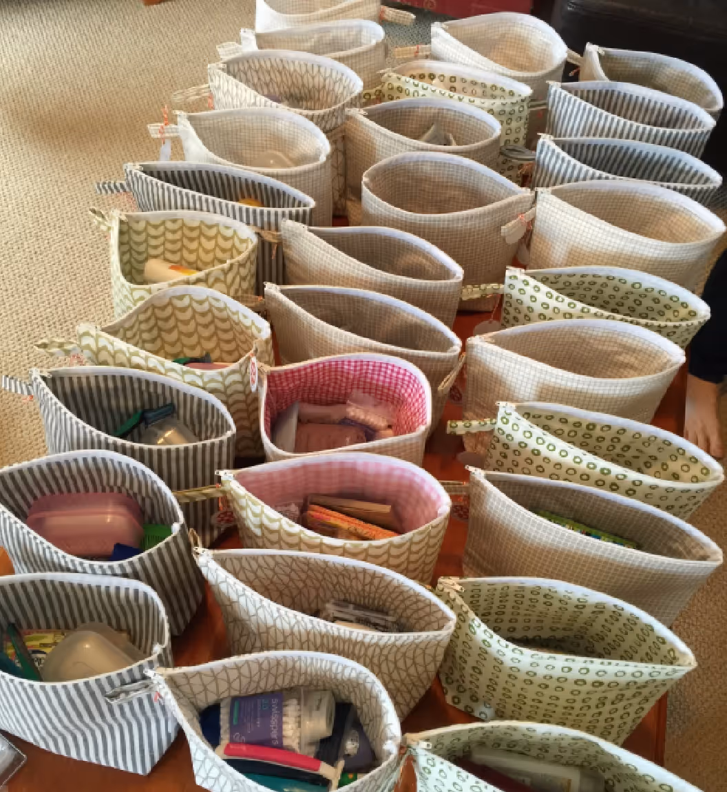 Rows of patterned fabric pouches on a table, each containing various small items.