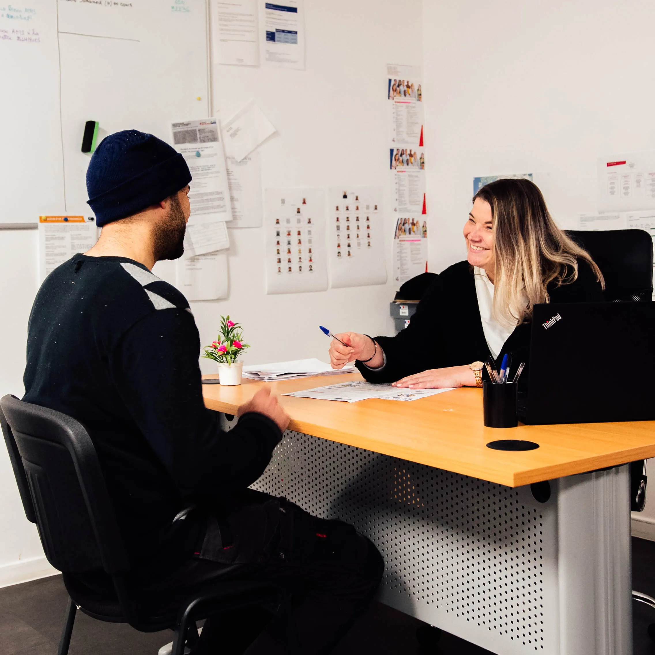 Photo de deux personnes discutant autour d'un bureau