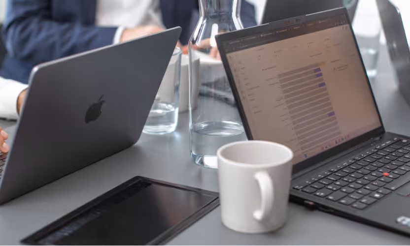 Aufnahme von Laptops auf einem Tisch während einer Meeting Situation.