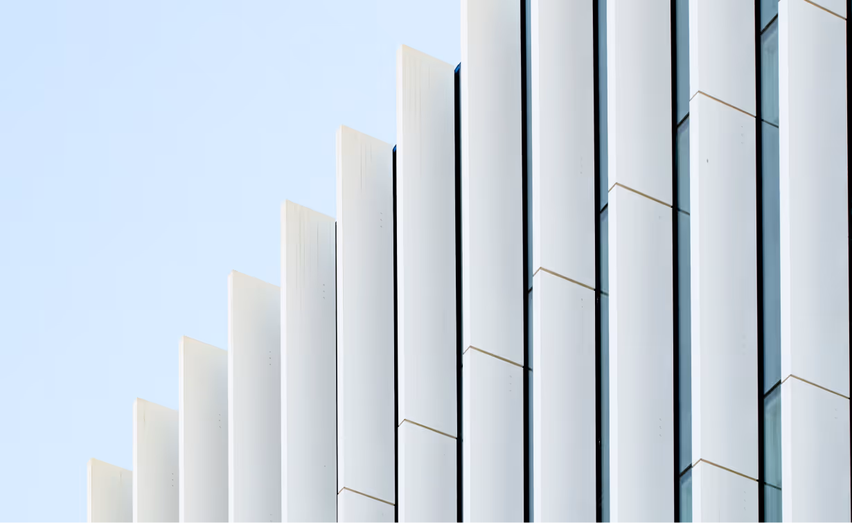 Modern building facade with vertical white slats against a blue sky
