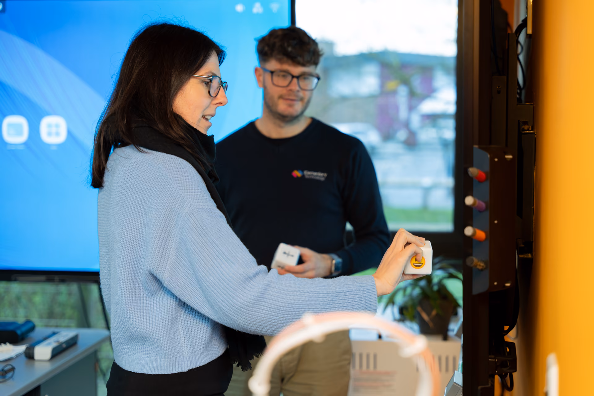 A man and woman testing features on an interactive touchscreen.