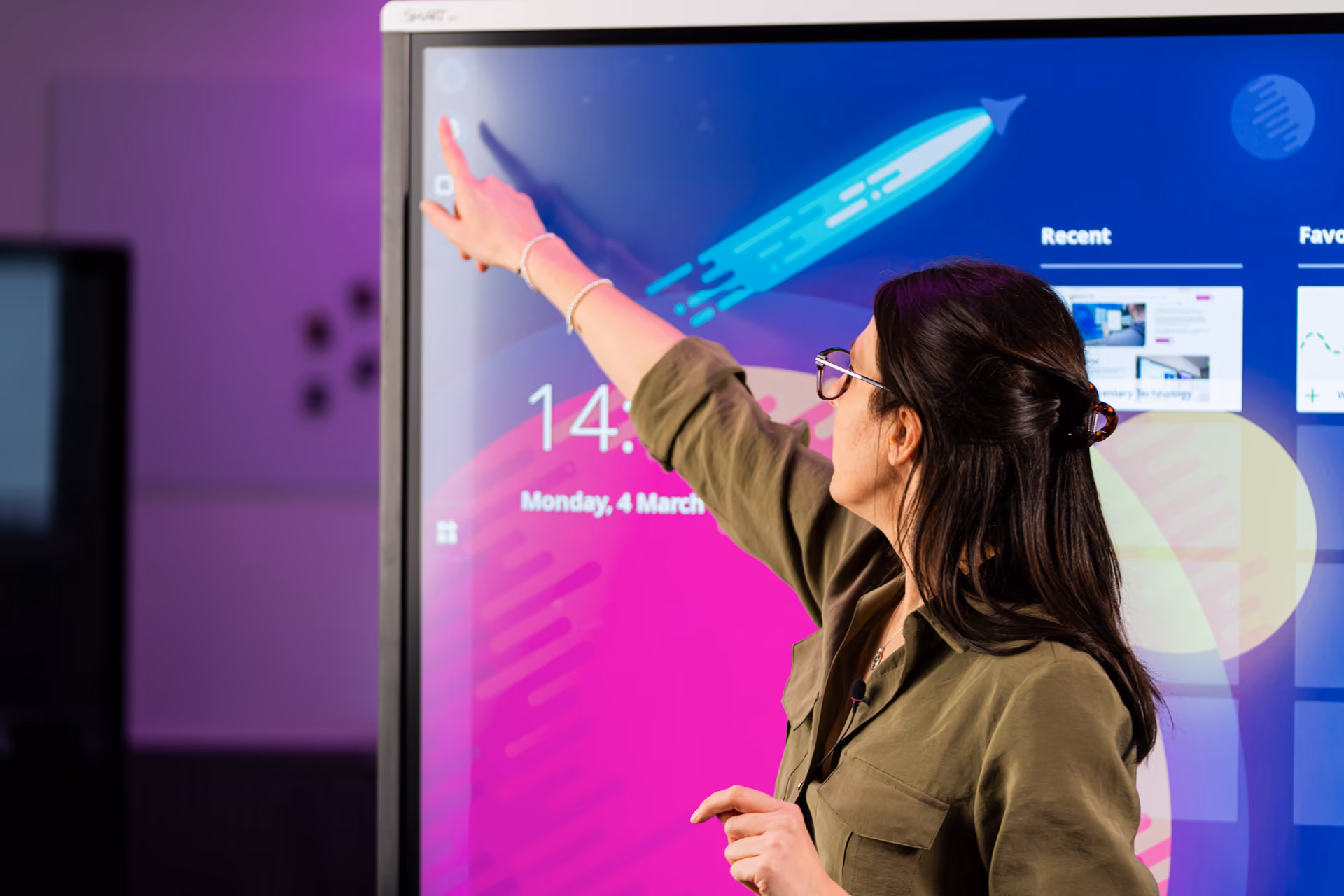 A woman using an interactive touchscreen for teaching.