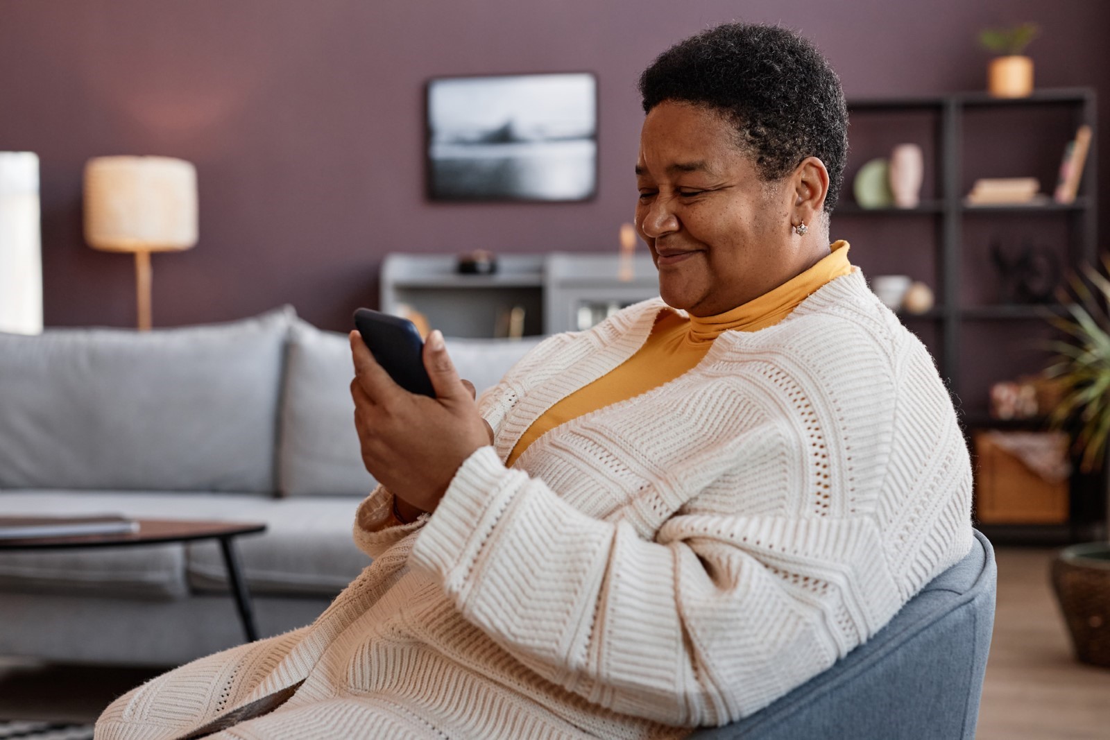 African American senior woman is looking up her blood sugar history on her phone.