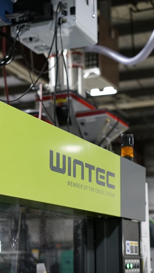 A green wintec Injection molding machine