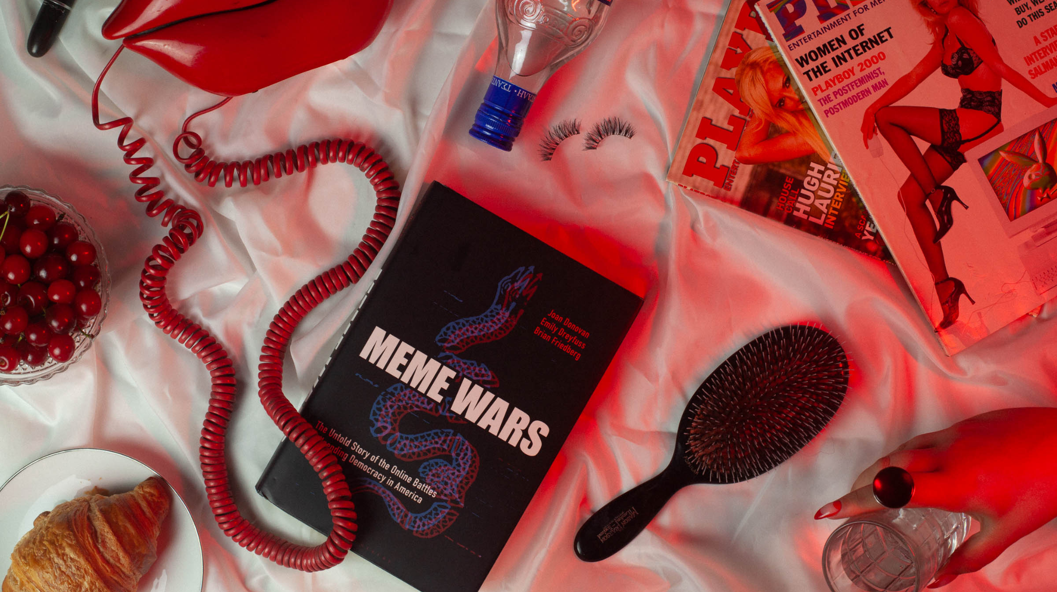 Provocative perfume lifestyle flatlay with vintage telephone, false lashes, cherries and alternative magazines representing horny fragrance culture and sexual aesthetics